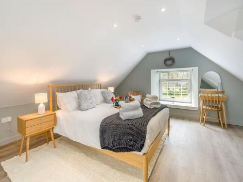 a bedroom with a large bed and a window at Blackside Cottage in stunning Ayrshire countryside in Mauchline