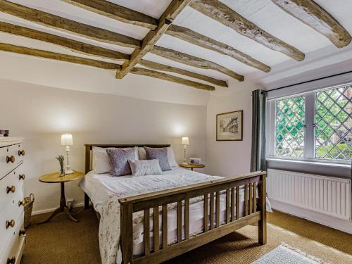 a bedroom with a bed and a window at Orions Cottage in Chilham