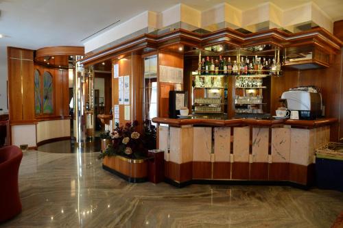 a bar in a restaurant with a counter at Hotel Posta in Comano Terme