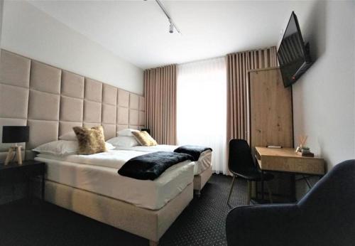 a hotel room with a bed and a television at Włodary Tennis Junior in Częstochowa