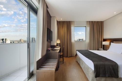a hotel room with a bed and a large window at Windsor Brasilia Hotel in Brasilia
