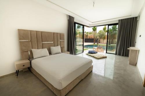 a bedroom with a large bed and a large window at Villa Design à Marrakech in Marrakech