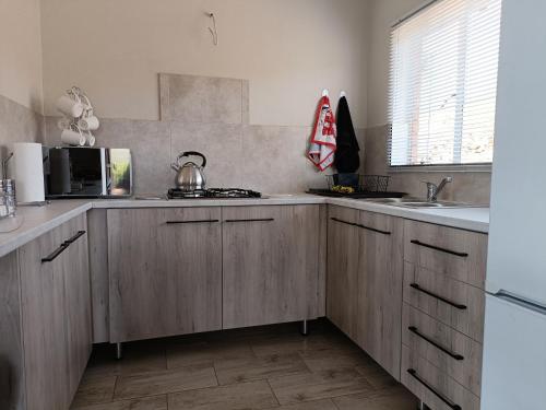 a kitchen with wooden cabinets and a sink at Sedgefield Lodge in Witbank