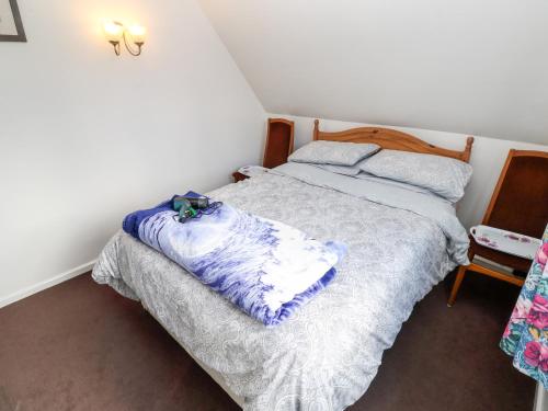 a bedroom with a bed with a blanket on it at Merlins Flight in Hayle