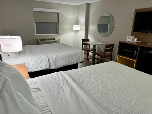 a hotel room with two beds and a table at Days Inn by Wyndham Sarasota I-75 in Sarasota