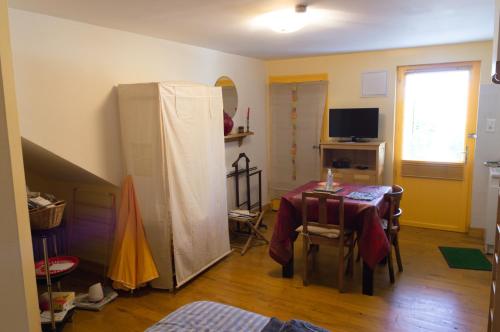 ein Wohnzimmer mit einem Tisch und einem Kühlschrank in der Unterkunft Studio calme et chaleureux in Brive-la-Gaillarde