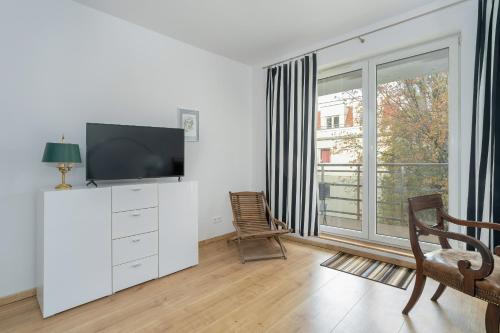 a living room with a tv and a window at Stylish Studio for 2 with Balcony Robocza Poznań by Renters in Poznań