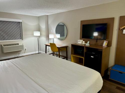 a hotel room with a bed and a television at Days Inn by Wyndham Sarasota I-75 in Sarasota