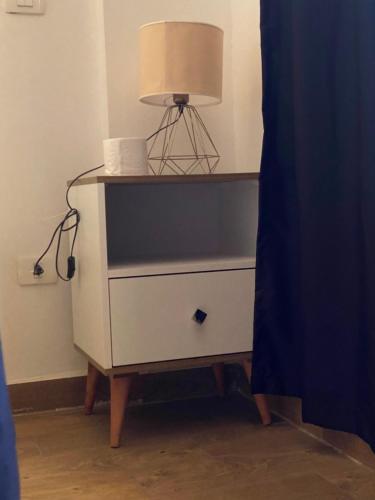 uma cómoda branca com um candeeiro em cima em Master Private Room in an apartment near Madinty em Madīnat ash Shurūq