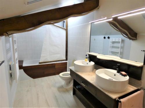 a bathroom with two sinks and a toilet and a mirror at Pechicou in Orx