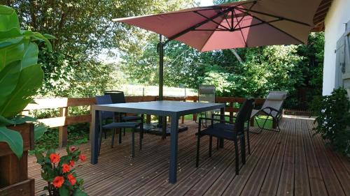 a table and chairs and an umbrella on a deck at Pechicou in Orx