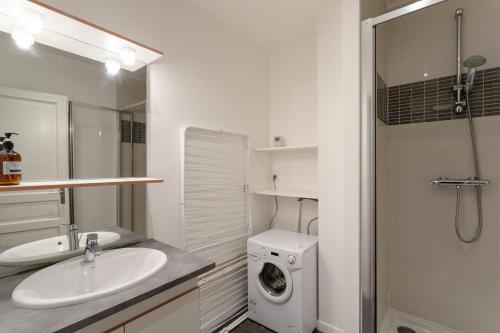 une salle de bain avec un lavabo et une machine à laver dans l'établissement L'ECRIVAIN by Cocoonr, à Rennes
