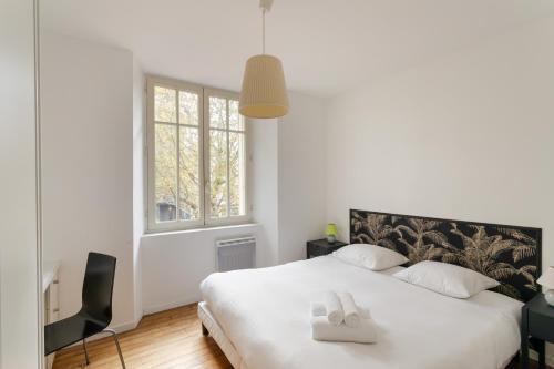 une chambre avec un lit avec deux serviettes blanches dessus dans l'établissement L'ECRIVAIN by Cocoonr, à Rennes