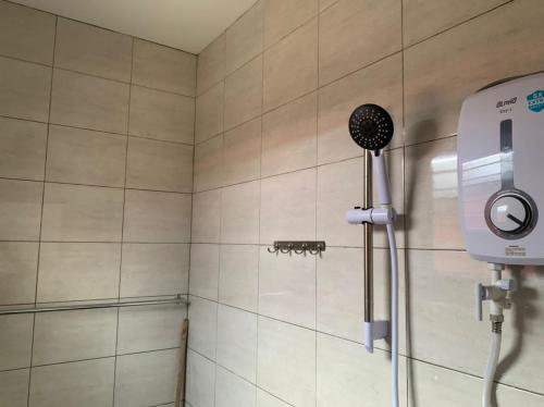 a shower with a blow dryer in a bathroom at 15 min to Qing Xin Ling Cultural Village Ipoh in Ipoh