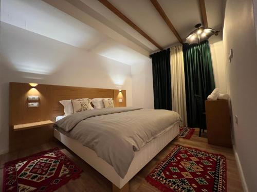 a bedroom with a large bed and two rugs at Chestnut Hill in Kolgecaj