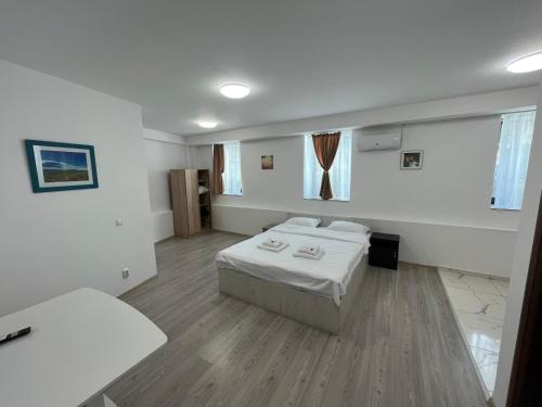 a white room with a bed and a table at Boutique Hotel Elena Doamna in Iaşi