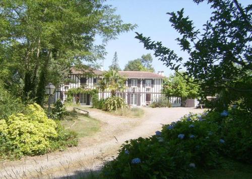 a large white house with trees and a driveway at Les sables landais in Gourbera
