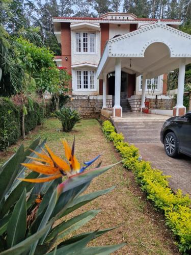 una casa con un coche aparcado delante de ella en Narmada Holiday Home, en Ooty
