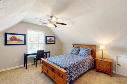 a bedroom with a bed and a desk and a ceiling fan at Goshen Getaway in Augusta