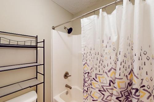 a bathroom with a shower curtain and a toilet at Goshen Getaway in Augusta