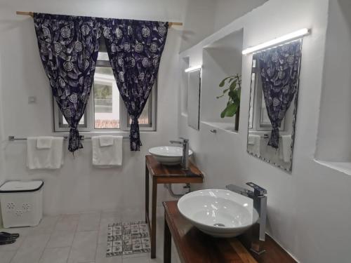 a bathroom with two sinks and a window at Mjanaheri Beach Villas in Bwejuu