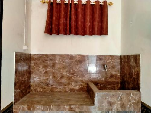 uma banheira num quarto com uma cortina vermelha em GH SIRNAMISKIN em Bandung