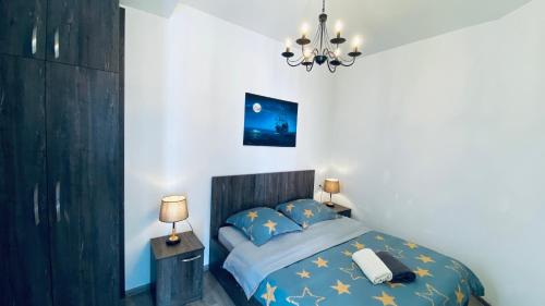 1 dormitorio con cama y lámpara de araña en Studio apartment with balcony in Tbilisi, en Tiflis