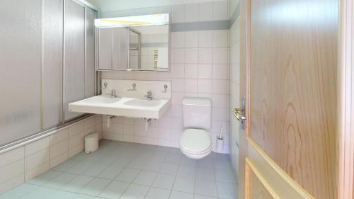 a bathroom with a toilet and a sink and a mirror at Somplatz 6 in Champfer