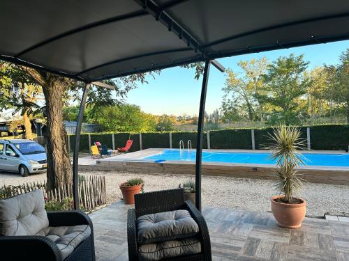 un patio avec deux chaises et une piscine dans l'établissement Chambre chez Alain et Armelle, à Avoine
