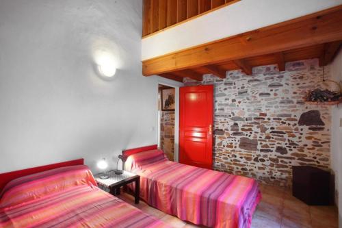 - une chambre avec 2 lits et un mur en briques dans l'établissement Le zihans, à Port-de-Lanne