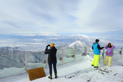 a group of people taking pictures at the top of a mountain at T Hotel Ryuoo in Shimotakai