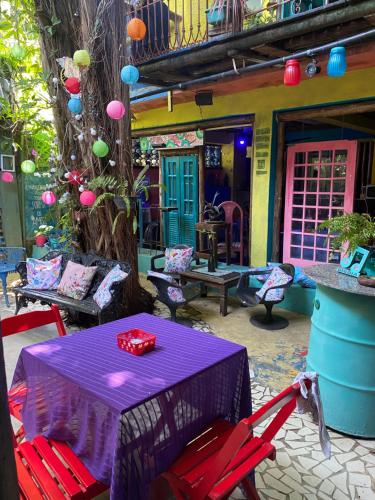 a patio with a purple table and red chairs at Pousada Babel in Rio de Janeiro