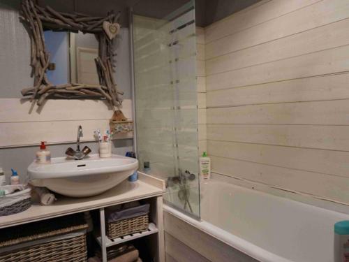 une salle de bain avec un lavabo et une baignoire dans l'établissement Charmant studio à Pra Loup 1600, proche des pistes avec balcon et wifi - FR-1-165A-14, à Uvernet