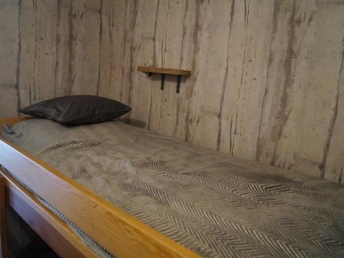 a bed in a room with a wooden wall at Studio Enchastrayes, 1 pièce, 4 personnes - FR-1-165A-22 in Enchastrayes