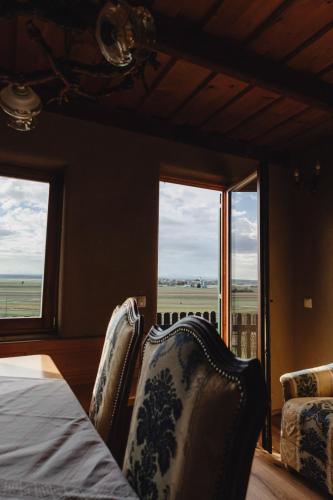 a bedroom with a bed and two chairs and windows at Holiday House Clavis in Dobrovnik