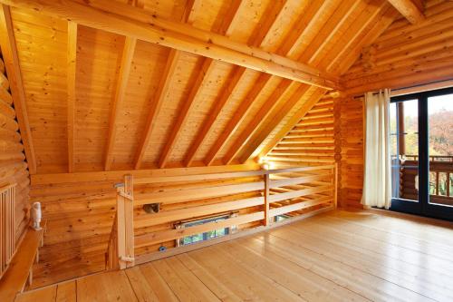 a room with a wooden wall in a log cabin at Mühlenblick in Medebach