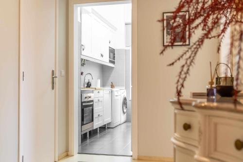 an open door to a kitchen with white appliances at Apart T3 com piscina tenis ginasio e parq infant in Lisbon