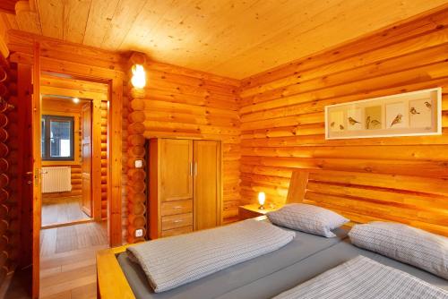 um quarto com uma cama num chalé de madeira em Mühlenblick em Medebach