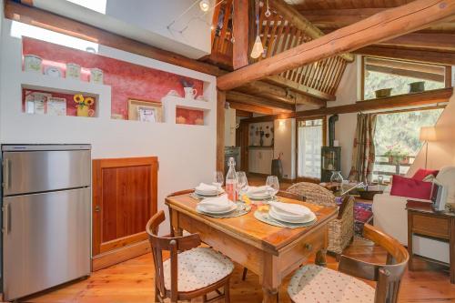 a kitchen and dining room with a wooden table and chairs at Romito Lodge Apartment Mountain Retreat - Happy Rentals in Cesana Torinese