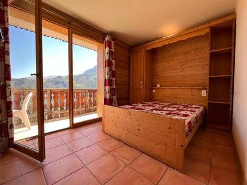 um quarto com uma cama e uma grande janela em Appartement Pra-Loup, 3 pièces, 8 personnes - FR-1-165A-45 em Uvernet