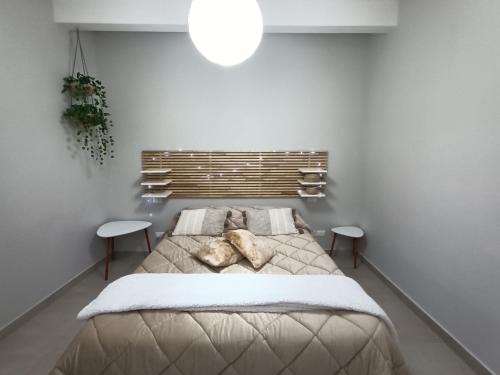 een slaapkamer met een groot bed en 2 tafels bij Maison La Reggia in Caserta