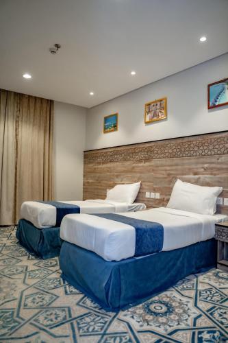 two beds in a hotel room with at فندق ليمة الذهبي in Mecca