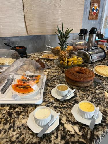 a counter top with a bunch of food on it at Pousada Escotilha in Arraial do Cabo