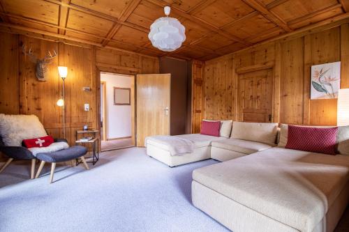 a living room with a couch and a chair at Weisshorn Apartment by Arosa Holiday in Arosa