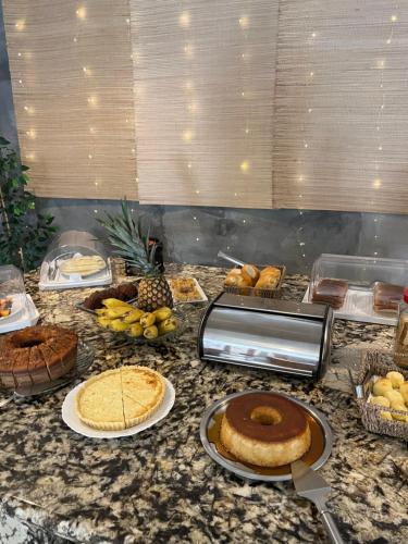 a counter top with pies and other food on it at Pousada Escotilha in Arraial do Cabo