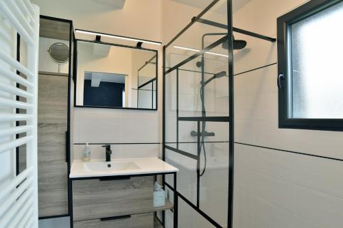 une salle de bain avec un lavabo et une douche en verre dans l'établissement L'escale de Rothéneuf - Jolie maison proche plage, à Saint-Malo