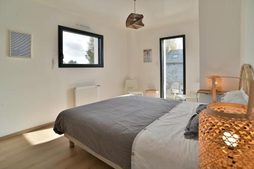 une chambre avec un grand lit et une fenêtre dans l'établissement L'escale de Rothéneuf - Jolie maison proche plage, à Saint-Malo