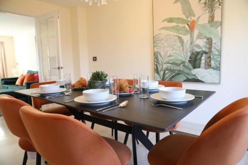 a dining room with a table and chairs at Spacious home with office and double driveway & FREE Wifi By ULTIMATE HOMES AWAY in Winnersh