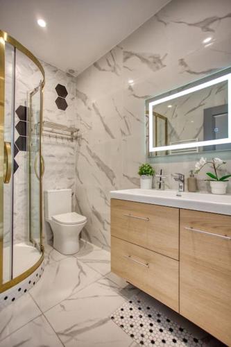 une salle de bain avec un lavabo, des toilettes et un miroir dans l'établissement Charming Apart NEW 2 Bedrooms with Aircon, à Paris