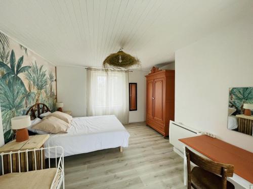 een slaapkamer met een bed, een tafel en een bureau bij Gite turon in Saint-Sever